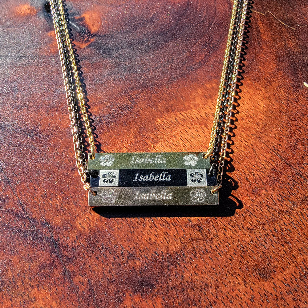 Stainless steel horizontal bar pendant engraved with hibiscus flowers and personalized