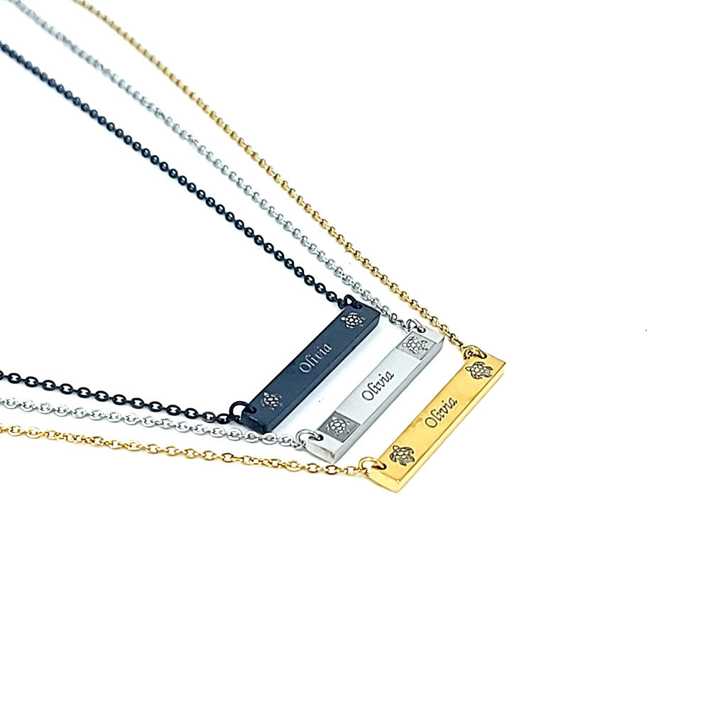 Stainless steel horizontal bar pendants engraved with honu designs on each side of a personalized message